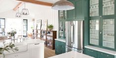 a kitchen with green cabinets and white counter tops is pictured in this image, the refrigerator has glass doors on both sides