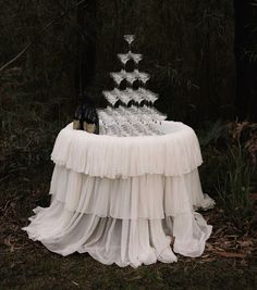 a table that has some wine glasses on top of it in front of the trees