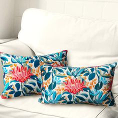 two blue and pink floral pillows on a white couch