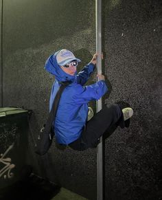 a man climbing up the side of a metal pole