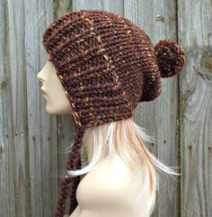 "Style: Chunky knit beanie with pom pom and braided ties, for men or women. Color: This sample hat is shown in Sequoia, a mix of browns, golds and rust. Sizes: One size fits average teen or adult head size of 20\" to 23\" (50.5 cm to 58 cm). Fiber Content: 80% acrylic, 20% Wool Characteristics: Chunky, very soft, warm and cozy. Care Instructions: Hand wash, dry flat. Every item from Pixiebell is handmade and knit or crocheted to order, unless otherwise stated in title of the item as \"ready to s Knit Slouchy Hats, Brown Beanie, Hat With Pom Pom, Flap Hat, Crochet Hat For Women, Brown Hat, Chunky Knit Hat, Ear Flap Hats, Mens Hat