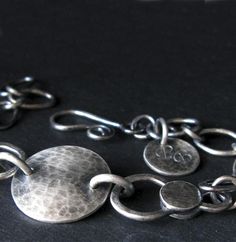 A rustic handmade chain link bracelet handcrafted from sterling silver. Each component has been individually made then oxidized and brushed for an antique appearance.The Details.∞ Artisan handmade∞ Sterling silver∞ Measures 7" long∞ Focal disc measure 5/8"∞ Allow up to 14 business days for fabrication before shipment∞ Gift box included∞ Made in the USA Unique Antique Silver Bracelet With Oxidized Finish, Unique Antique Silver Bracelets With Oxidized Finish, Unique Round Bracelets With Oxidized Finish, Rustic Round Jewelry With Oxidized Finish, Rustic Silver Bracelets For Gifts, Rustic Silver Bracelet For Gift, Artisan Silver Bracelet With Oxidized Finish, Artisan Sterling Silver Bracelet With Oxidized Finish, Artisan Hand Forged Sterling Silver Bracelets