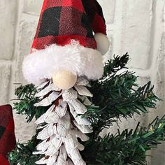 a red and black plaid christmas tree with a santa hat on it's head