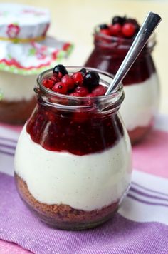 two small jars filled with food sitting on top of a purple table cloth next to each other