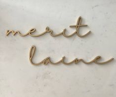 two metal letters that spell out the word merit lave on a marble surface