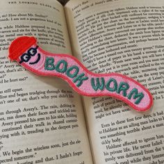 a book worm brooch sitting on top of an open book