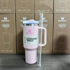 the pink tumbler is next to some boxes