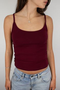 a woman wearing a red tank top and jeans