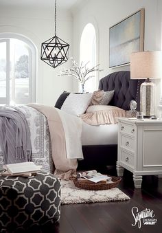 a bed room with a neatly made bed and a chandelier