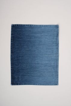 a piece of blue denim fabric on a white tablecloth with an empty space in the middle