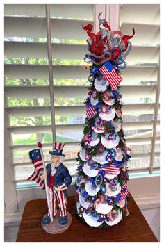 a decorated christmas tree sitting on top of a wooden table