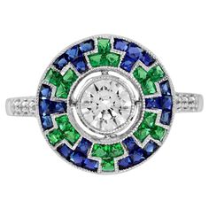 A chic diamond with blue sapphire and emerald target ring. The central round diamond is securely milgrain set into white gold as the centerpiece of this stunning ring. Designed to resemble a stylish geometric wheel, French cut blue sapphires and emeralds surround the center diamond. Combining the birthstone for April, May, and September this will make a perfect gift to be worn. Ring Information Style: Art-deco Metal: 18K White Gold Total weight: 4.40 g. (approx. total weight) Ring size: US 3 – 8 Emerald Art Deco, Target Ring, Emerald Art, French Cut, Estilo Art Deco, Art Deco Style, Cluster Ring, Ring Box, Style Art