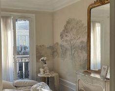 a white bed sitting next to a window in a bedroom