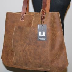 Genuine leather. Unlined interior. 1 exterior small pocket. 16" L x 16.5" W x 5." D. Dust Bag Included for Storage This is the perfect bag for teachers, you can just throw you papers, laptop etc inside and go, all while being stylish. Brown Leather-backed Tote Travel Bag, Brown Rectangular Shoulder Bag With Anti-theft Pocket, Brown Shoulder Bag With Anti-theft Pocket For Everyday Carry, Dark Tan Leather-lined Tote Bag, Brown Leather Rectangular Backpack With Anti-theft Pocket, Brown Leather Tote Bag, Tote Bag With Pockets, Brown Leather Totes, Perfect Bag