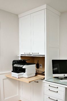 a computer desk with printer, scanner and monitor on it in a home office area