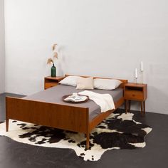 a bed sitting on top of a black and white floor next to a wooden table