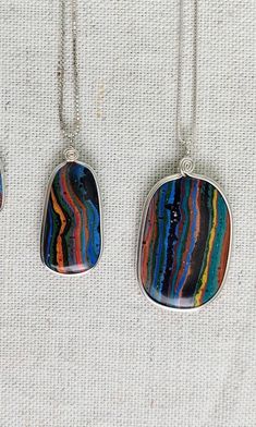 "Choice of 3 Fun Amazing Rainbow Calsilica Pendant Necklaces! These Multi color stones are perimeter wire wrapped with Sterling Silver by us. We finish them with their simple design, which enhances them while bringing out the individual characteristics and colors of each pendant! This stone is Mostly man made, while using the natural calcite as a base! The perimeter wire wrap holds the stone tight so they do not break like other designers slab pendants that are only drilled. The swirl at the top Artsy Multicolor Round Pendant Jewelry, Multicolor Rectangular Pendant Necklace For Gift, Artsy Multicolor Jewelry With Large Pendant, Artsy Sterling Silver Pendant Necklace, Multicolor Wire Wrapped Pendant Jewelry, Multicolor Natural Stones Round Pendant Jewelry, Multicolor Gemstone Oval Pendant Jewelry, Multicolor Oval Pendant Gemstone Jewelry, Multicolor Necklace With Large Rectangular Pendant