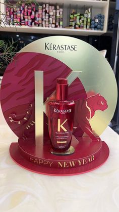 a bottle of kerastase happy new year on display in front of a sign