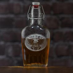 a bottle of beer sitting on top of a wooden table next to a brick wall