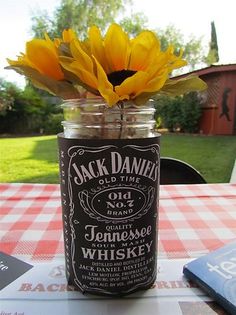 a mason jar filled with sunflowers sitting on top of a table