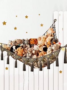 a hammock filled with stuffed animals and tassels hanging from the ceiling