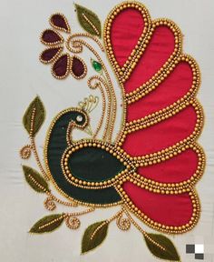 a red and black bird with green leaves on it's back side is embroidered onto the fabric