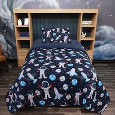 a bed room with a neatly made bed and space themed comforter on top of it