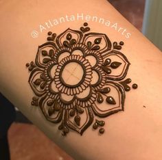 a woman's arm with a henna tattoo on the side of her arm