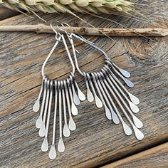 Silver Teardrop Boho Fan Earrings: These silver fan paddle earrings are the perfect mix of geometric & boho and will compliment any outfit! Graduated hammered paddles hang from a beautifully crafted teardrop focal point. These earrings are handcrafted from silver plated jewelers grade brass. They are approximately 2.75 inches in length and .62 inches at the widest portion. To view more of my original jewelry designs, visit: https://www.etsy.com/shop/TheBeadCounter Sterling Silver Teardrop Chandelier Earrings, Bohemian Teardrop Sterling Silver Chandelier Earrings, Modern Nickel-free Dangle Teardrop Earrings, Bohemian Sterling Silver Teardrop Chandelier Earrings, Bohemian Drop Metal Earrings, Silver Bohemian Teardrop Dangle Earrings, Bohemian Long Drop Teardrop Earrings, Bohemian Teardrop Long Drop Earrings, Bohemian Teardrop Earrings Nickel Free For Everyday