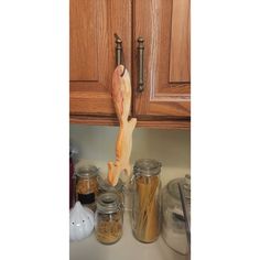 a wooden spoon is hanging on the kitchen cabinet door