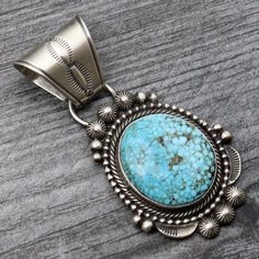 Indulge in the stunning beauty of the Birdseye Kingman Pendant by Tom Lewis. Handcrafted with exquisite attention to detail, this piece features a single Sterling silver setting encasing vibrant turquoise, surrounded by intricate twist and beaded wire. With its impressive size and weight, and a versatile 8mm bale, this pendant is a must-have for any jewelry collection. Make a bold statement and add it to your wardrobe today. Turquoise Jewelry With Intricate Design, Oxidized Turquoise Oval Jewelry, Elegant Turquoise Necklace With Oxidized Finish, Elegant Turquoise Jewelry With Large Pendant, Collectible Teardrop Turquoise Jewelry, Traditional Turquoise Cabochon Jewelry, Elegant Pendant Turquoise Necklace Collectible, Elegant Turquoise Pendant Necklace Collectible, Elegant Turquoise Pendant Necklace