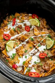 a slow cooker filled with mexican food and garnished with sour cream