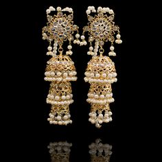 Perfect when you are looking to make a glorious and a majestic impact! Dreamy pair of earrings encrusted with CZ stones and laced with white pearl moti. Approximate earrings length is 4.5". Gold-plated on high-quality brass as the base metal. Made by order. Kindly allow 5-7 weeks for the delivery of this item. For custom or urgent requests, please contact support@alacouture.com. *Please Note: We use faux stones and beads in all of our jewelry. Elegant Jeweled Earrings For Reception, White Jhumkas With Intricate Design For Celebration, Bollywood Style Filigree Earrings For Festive Occasions, White Intricate Design Jhumkas For Celebration, Elegant Pearl Earrings For Reception, White Jhumkas With Intricate Design For Reception, Traditional Jeweled Pearl Earrings For Party, Reception White Jhumkas With Intricate Design, White Pearl Drop Earrings For Reception