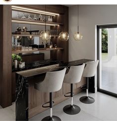 a kitchen with marble counter tops and bar stools in front of an open glass door