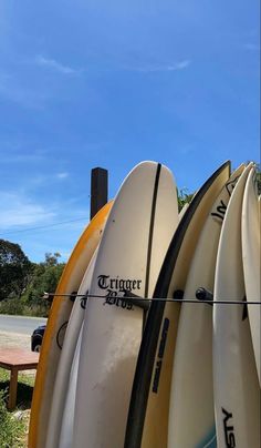 several surfboards are lined up against the fence