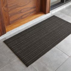 a door mat sitting on the floor in front of a wooden door