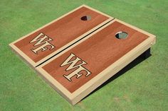 two brown and white cornhole game boards on green grass