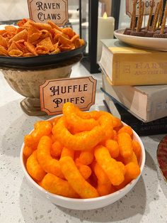 there is a bowl full of cheetos next to some books on the table