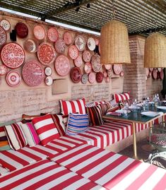 red and white striped couches in front of a wall with plates on it