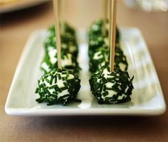 small appetizers with toothpicks in them on a white plate