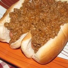 two hot dogs on buns covered in chili