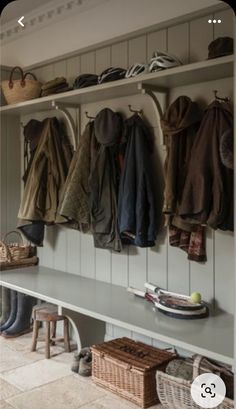 the coat rack is full of coats and hats on it's shelves in this entryway