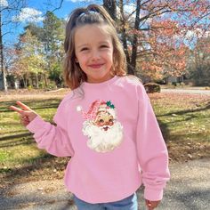 This cozy crewneck is the perfect gift for a girl or woman. Featuring the cute pink santa with leopard print hat, this shirt is stylish and cute winter wear. 𝐇𝐎𝐖 𝐓𝐎 𝐎𝐑𝐃𝐄𝐑 1. Select the size & color when applicable 2. Add the personalization (name, design etc) when required 3. Add to Cart & submit your order. 4. If ordered over $35, we have FREE shipping for you! 𝐀𝐋𝐖𝐀𝐘𝐒 𝐇𝐀𝐍𝐃𝐌𝐀𝐃𝐄 * Each item is handmade and made to order here in Florida! * We carry several different brands and use different brands for different listings, including Rabbit Skins®, Gildan®, Gerber Onesie®, Bella Canvas® and Comfort Colors®. G A R M E N T ∙ F E A T U R E S : * Unisex Fit * Commercial grade heat press S H I P P I N G * All items get sent via USPS first class mail * Priority 2-3 day shippin Casual Winter Tops With Cartoon Print, Cute Long Sleeve Winter Tops, Trendy Winter Tops With Cartoon Print, Cute Long Sleeve Tops For Winter, Christmas Long Sleeve Tops With Cartoon Print, Winter Cartoon Print Relaxed Fit Tops, Pink Letter Print Top For Winter, Winter Pink Top With Letter Print, Pink Tops With Letter Print For Winter