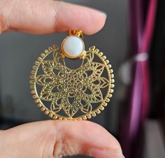 This is my masterpiece single design gold tone filigree pendant necklace with mother of pearl cabochon in between. This necklace is inspired from vintage era neckpieces. This metal work looks absolutely gorgeous on every age group. Item is made from pure brass and gold plated with 18k with guarantee of no corrosion of plating with regular use. D E T A I L S Diameter: 2" Disc pearl: 8mm Chain size: Adjustable from 12 to 18 inches Brass Coin Pendant Jewelry, Spiritual Brass Jewelry With Coin Pendant, Spiritual Brass Coin Pendant Jewelry, Spiritual Round Pendant Jewelry For Her, Elegant Metal Jewelry With Pearl Pendant, Gold Plated Coin Pendant Jewelry, Dainty Brass Medallion Jewelry, Brass Medallion Necklace For Gift, Handmade Yellow Gold Round Pendant Medallion Necklace