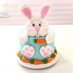 there is a cake decorated to look like a bunny with carrots on the side