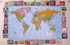 a world map with many different pictures on it and some magnets attached to the wall