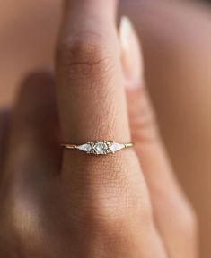 a woman's hand with a diamond ring on her finger, showing the side view