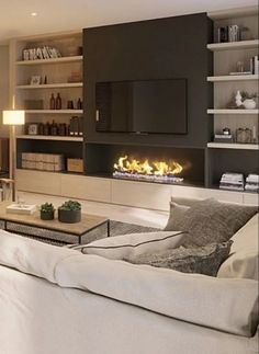 a living room filled with furniture and a flat screen tv mounted on a wall above a fire place