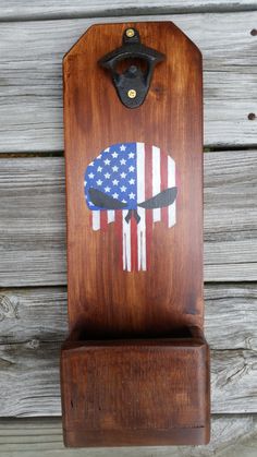 a wooden cutting board with an american flag design on it and a black iron holder