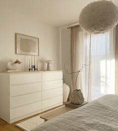 a bedroom with white furniture and large windows